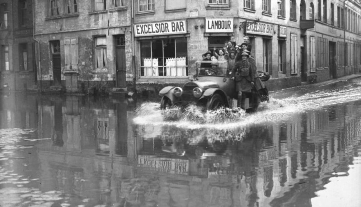 291_Civilians driving to their homes through flooded streets of Valenciennes on a Canadian car. November, 1918.
